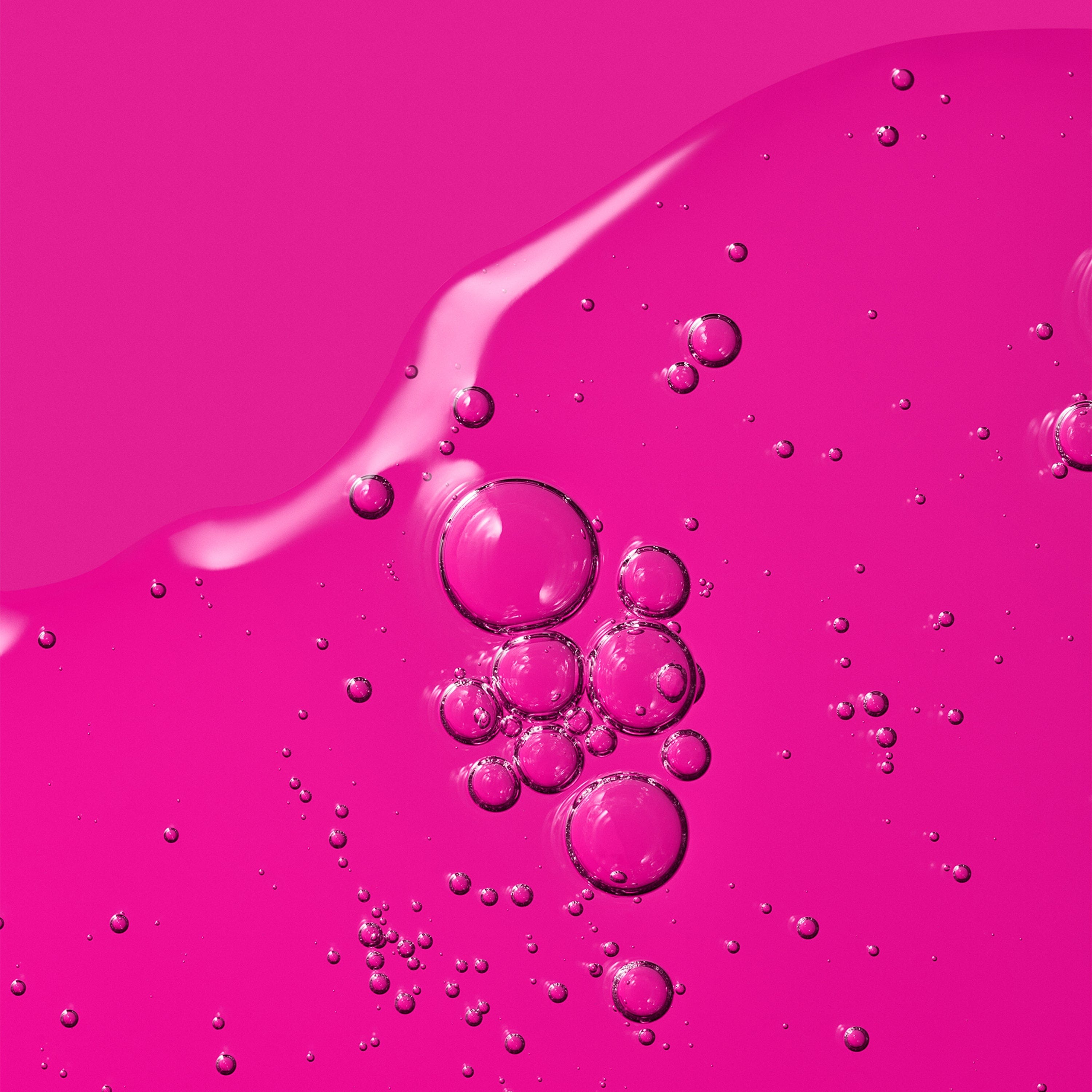 A vibrant pink gel texture with suspended air bubbles.