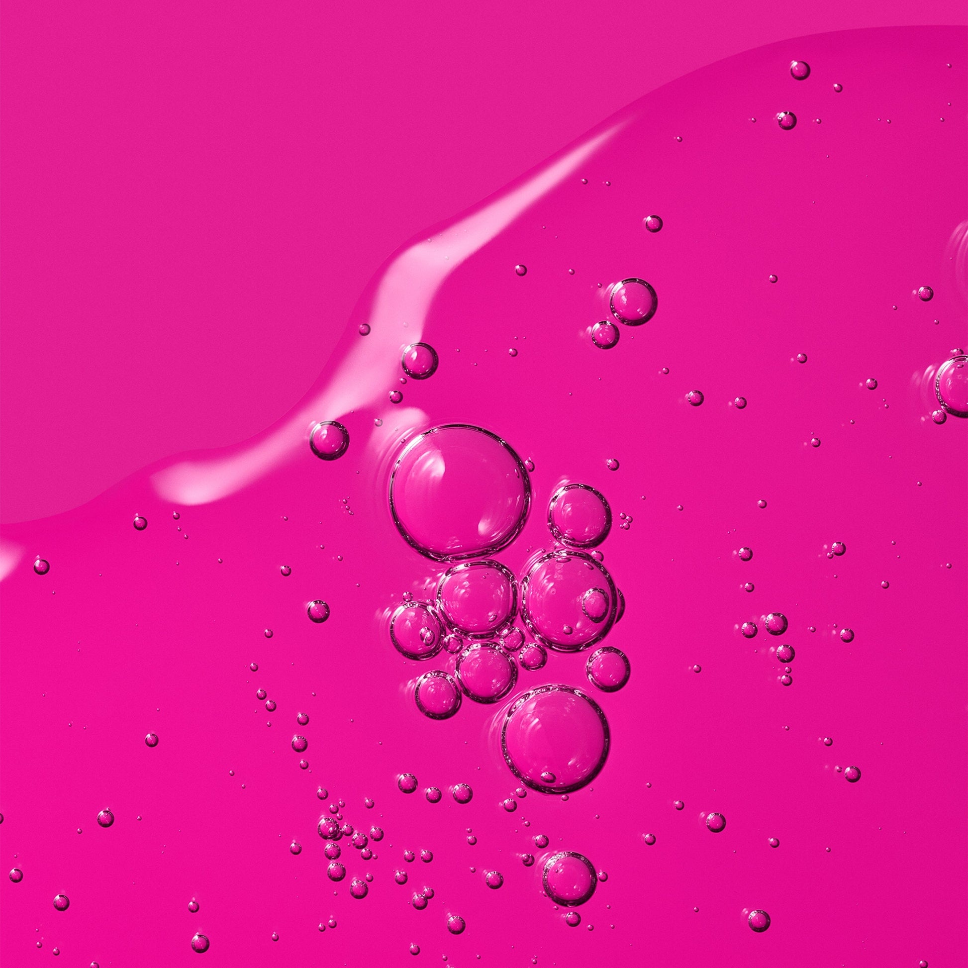 A vibrant pink gel texture with suspended air bubbles.