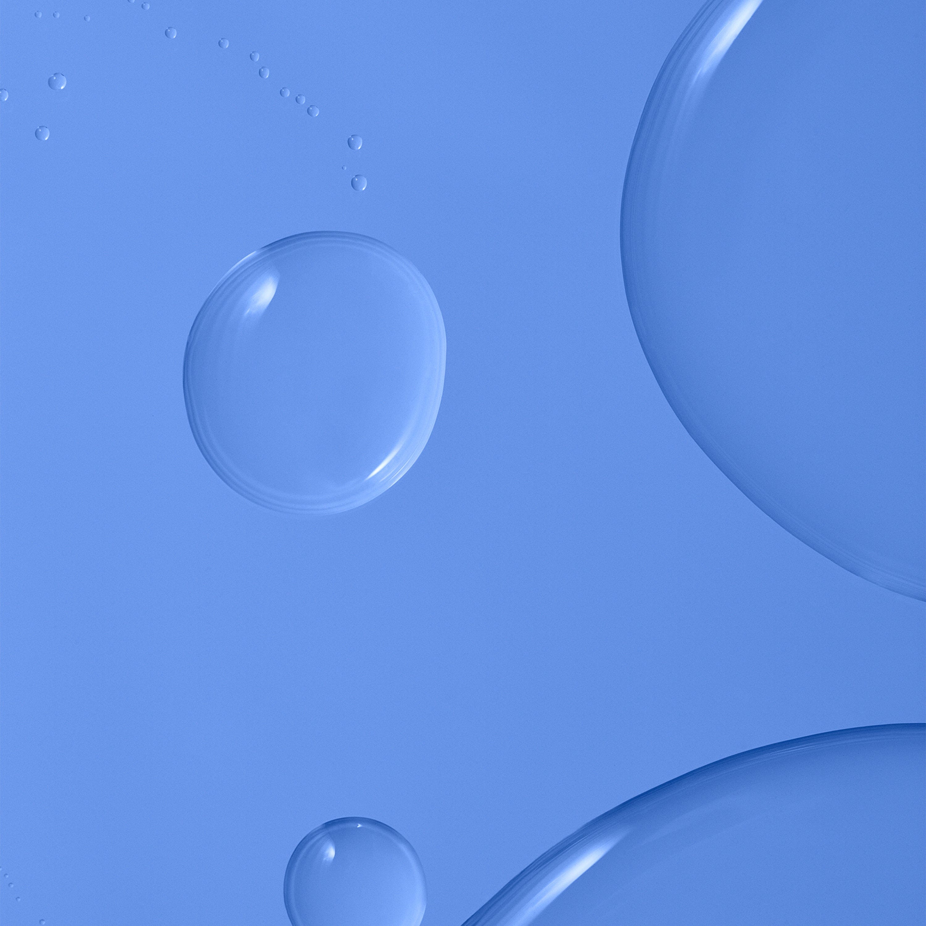 Bubbles and droplets of water against a soft blue background.