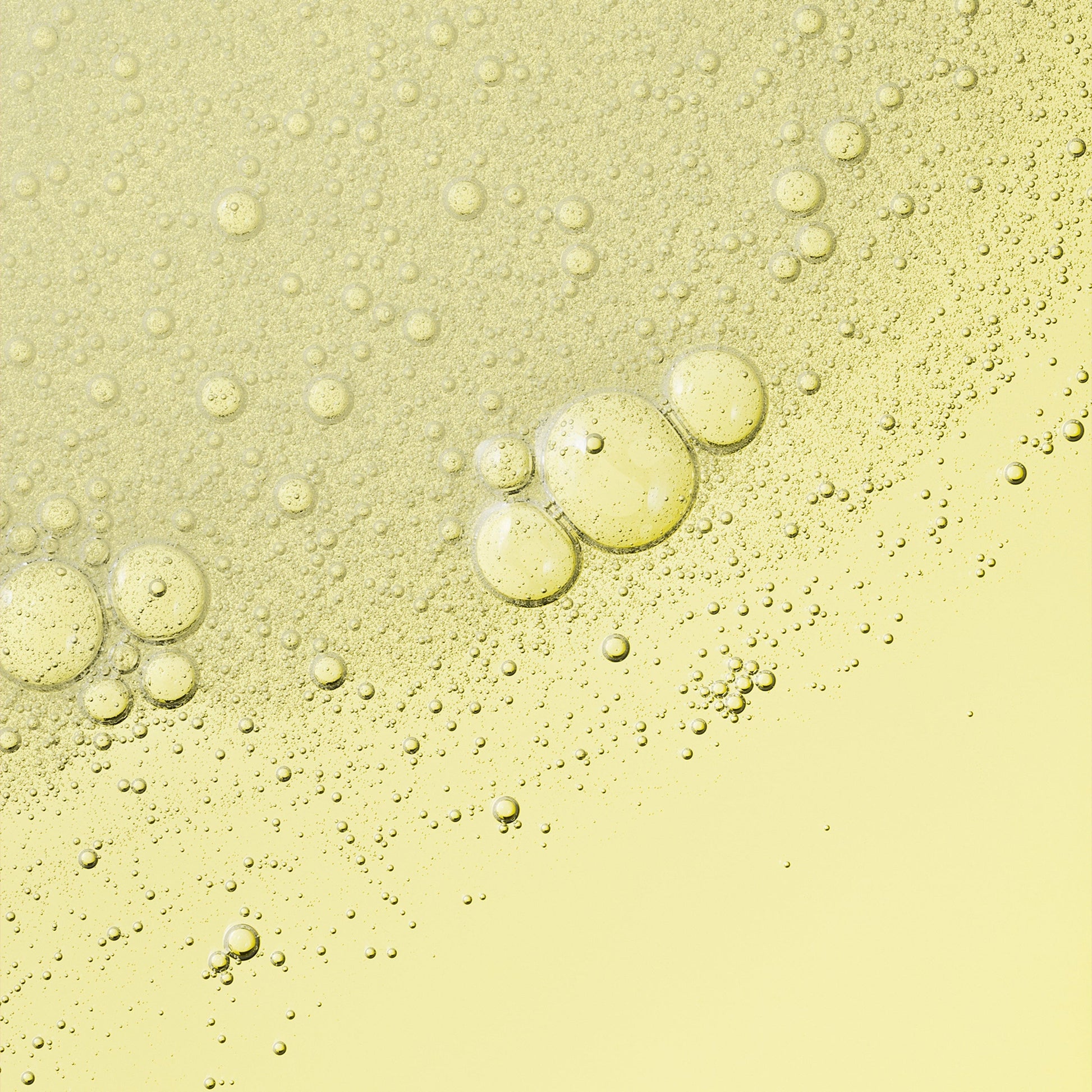 A yellow, bubbly liquid texture, with visible bubbles and droplets.