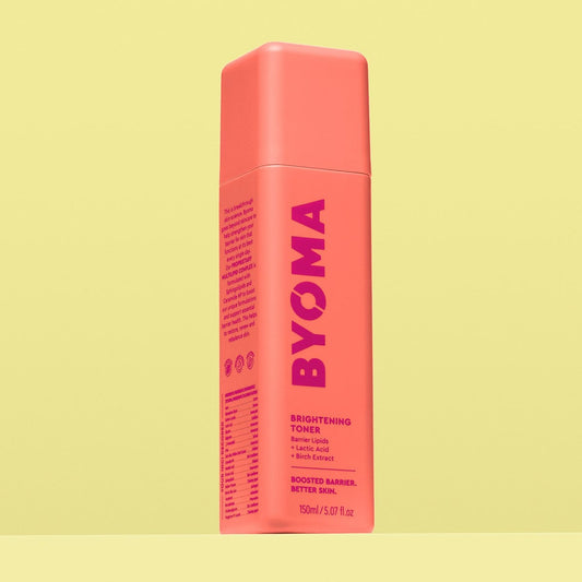 A BYOMA Brightening Toner bottle in a vibrant coral color.
