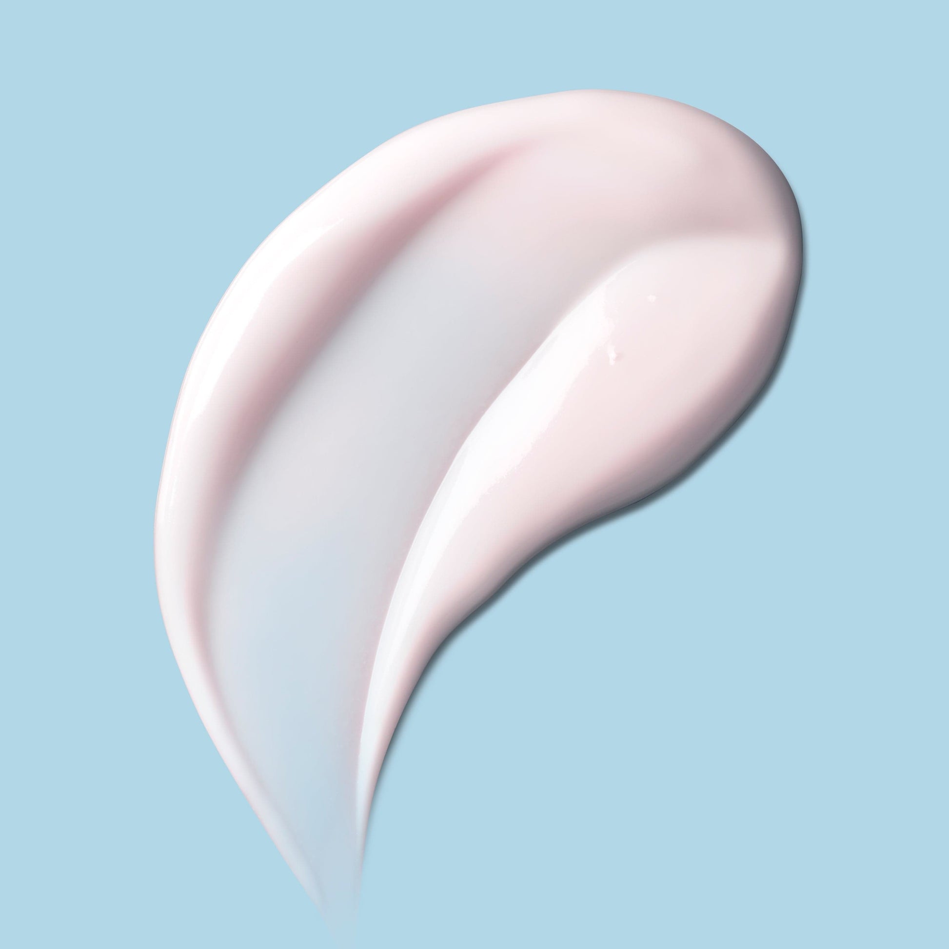 A swirl of soft, creamy moisturizer against a teal background.
