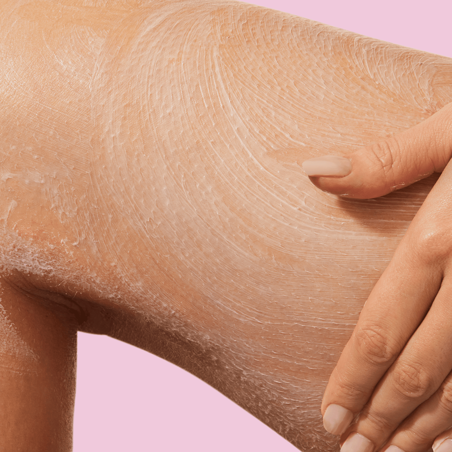 A hand applying product on the thighs.