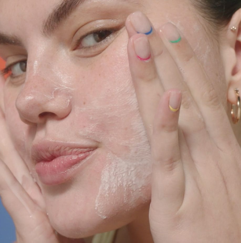 Woman applying cleanser to her face.