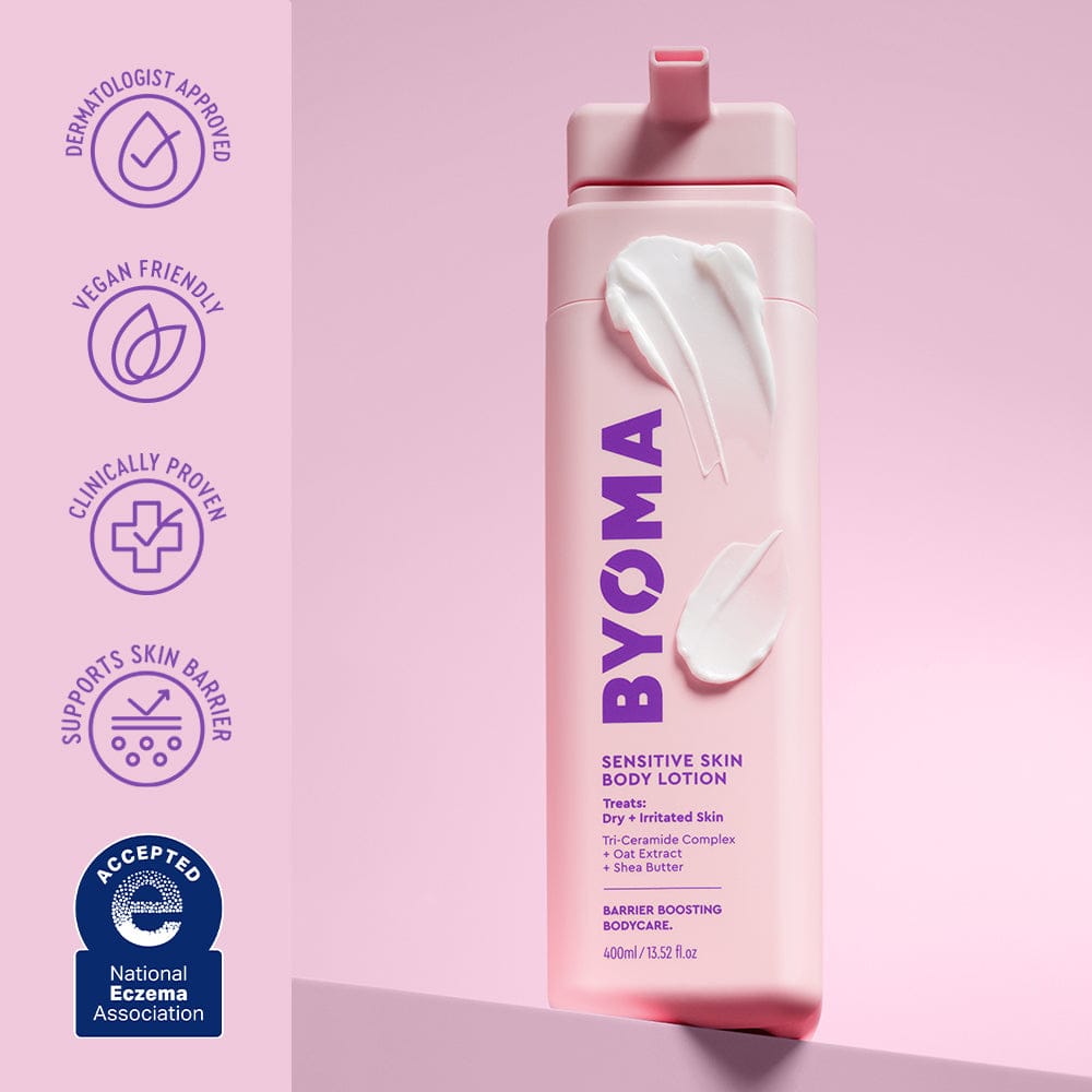 BYOMA sensitive skin body lotion bottle with branding and certification logos on a pink background