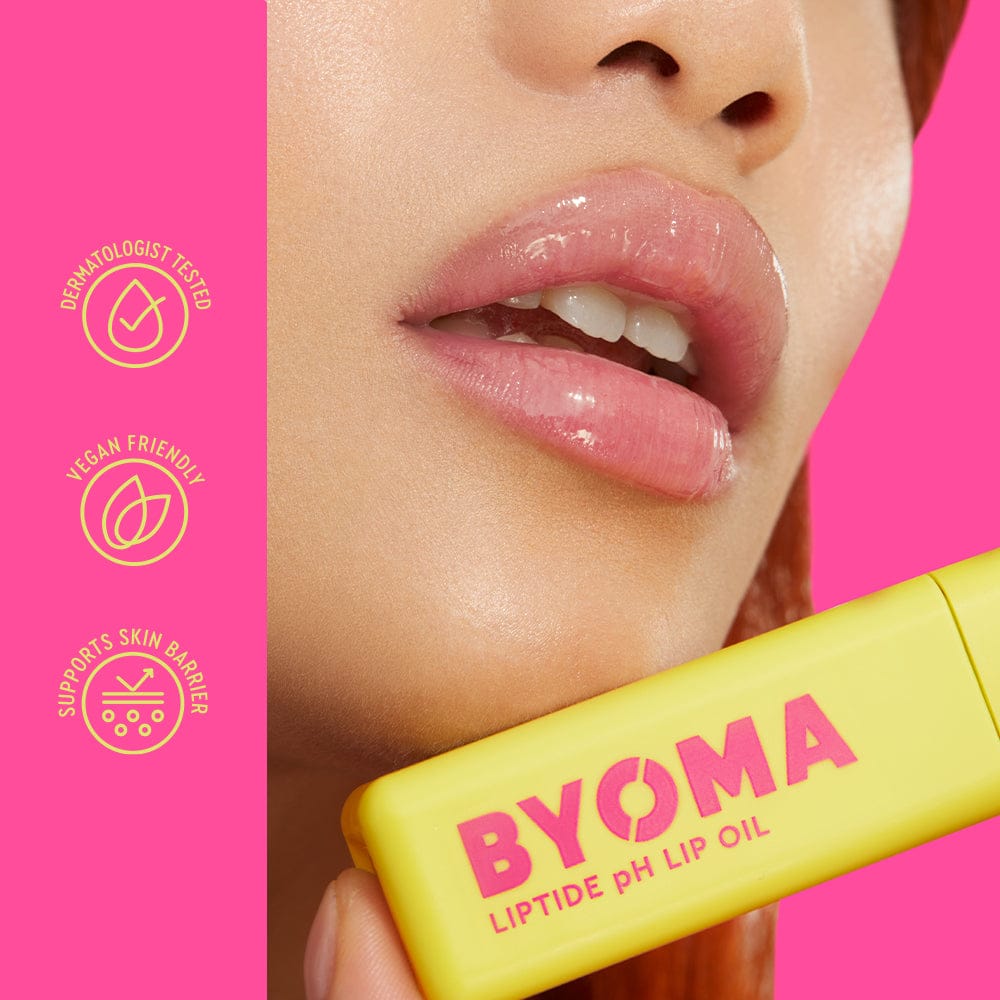 Yellow lip oil with 'BYOMA' branding held by a person against a pink background